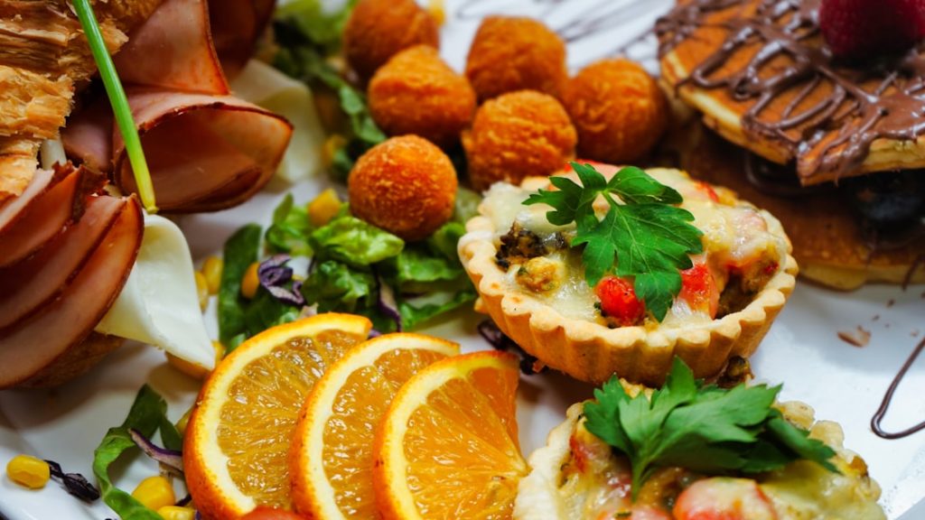 a-white-plate-topped-with-oranges-and-other-food-w0pjgpmgsiw